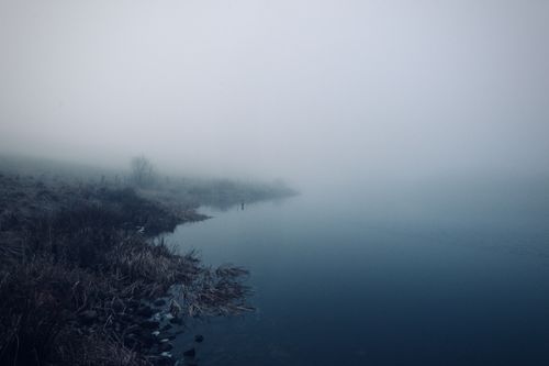 Free A serene foggy lake scene with misty ambiance, captured during winter creating an eerie, tranquil mood. Stock Photo