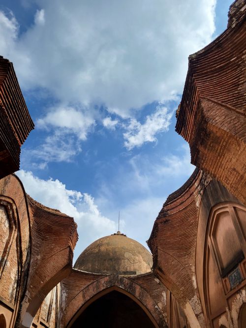 Free An upward view of ancient Mughal architecture against a bright blue sky in Murshidabad, India. Stock Photo
