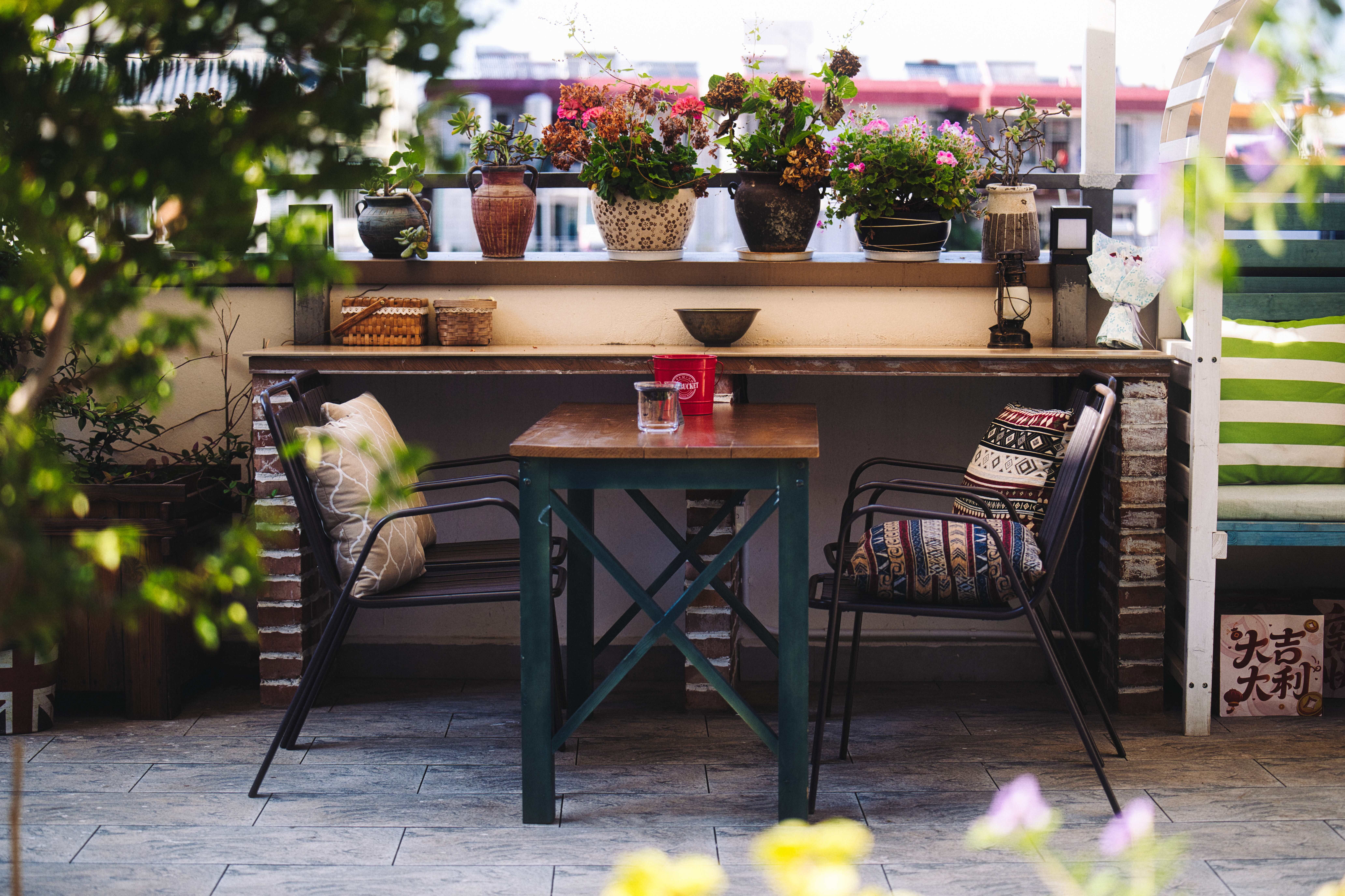 Mann richtet Beistelltisch auf moderner Terrasse ein