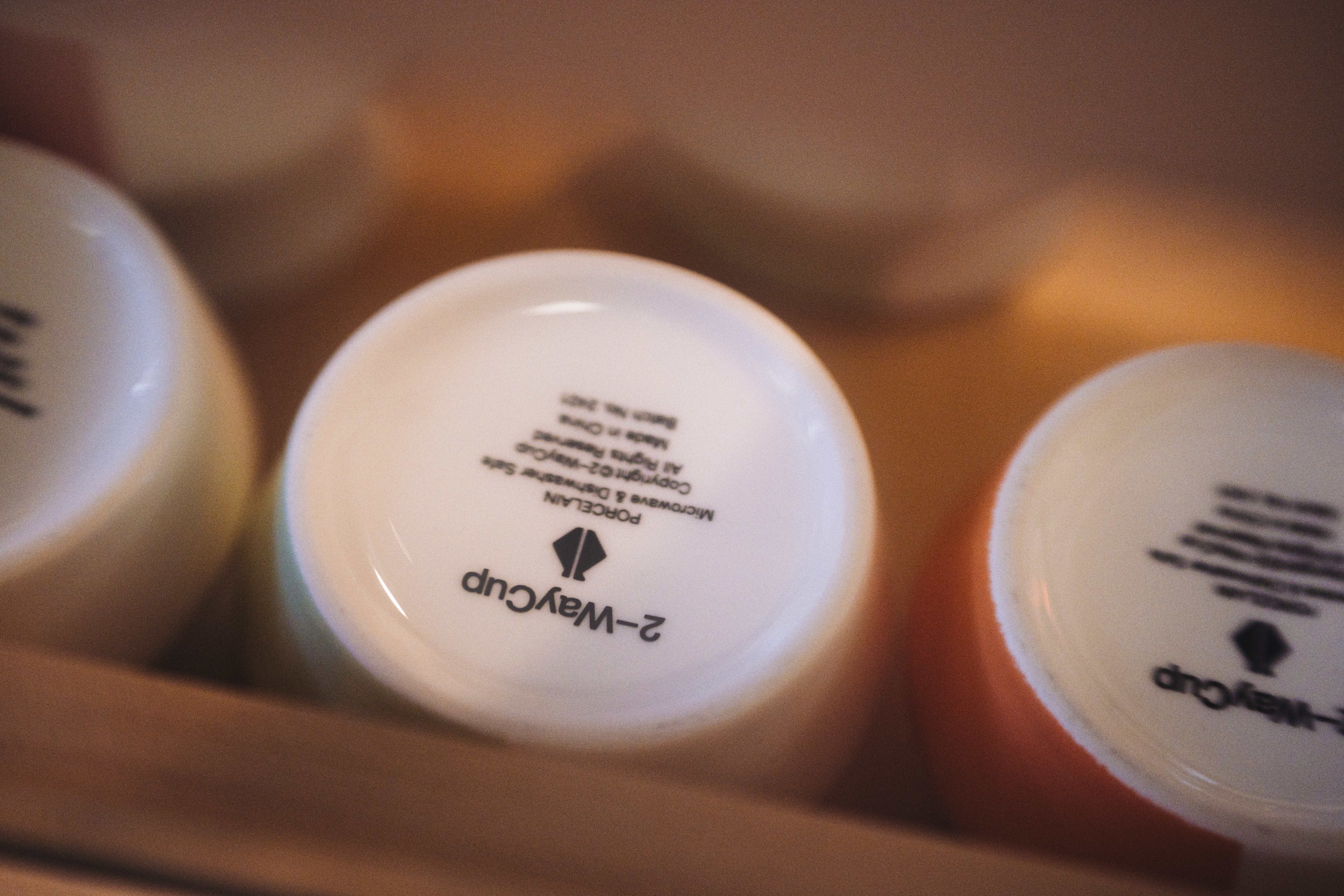 Artistic close-up of ceramic cups showing manufacturer marks on their bases, creating a unique perspective.