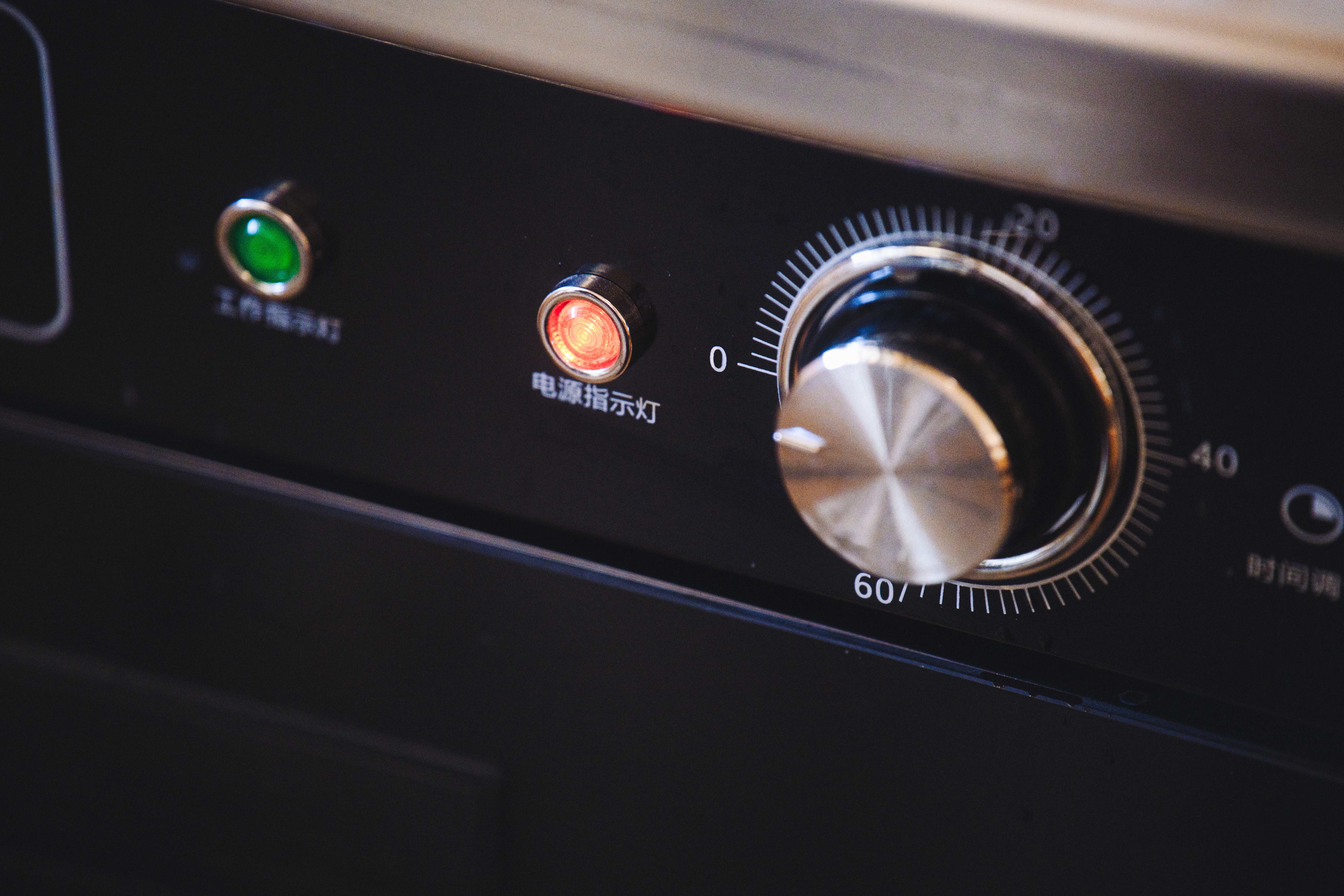 Detailed view of an appliance control panel featuring a dial and indicator lights.