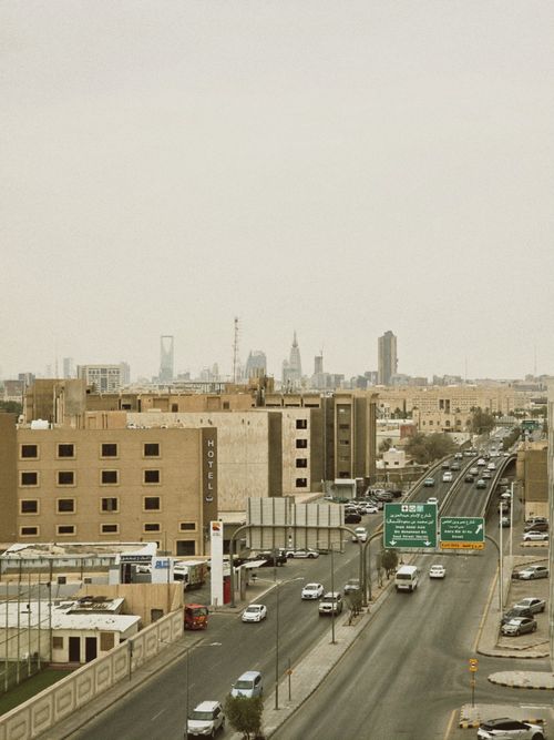 Free Aerial view of bustling Riyadh city streets with skyline in the background on a cloudy day. Stock Photo
