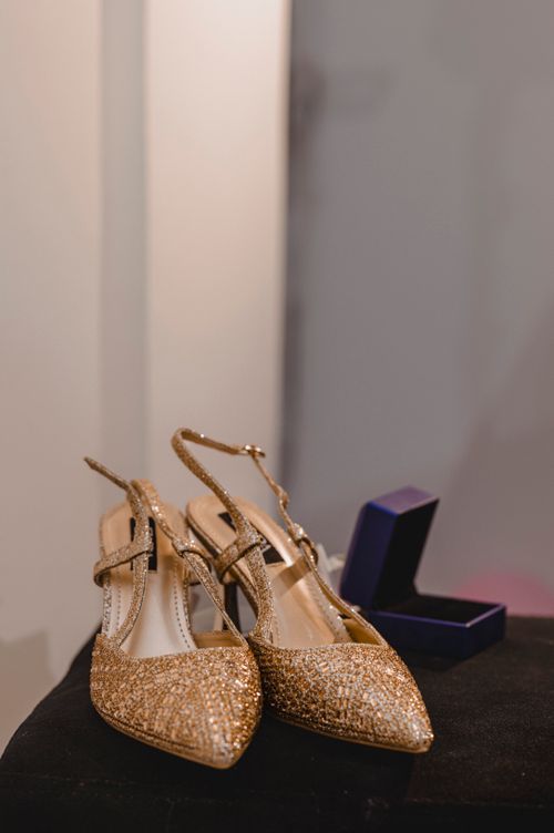 Free Stylish golden high heels displayed alongside a jewelry box, perfect for formal events. Stock Photo