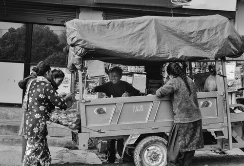 Free A lively street market with vendors selling goods from a cart in black and white. Stock Photo