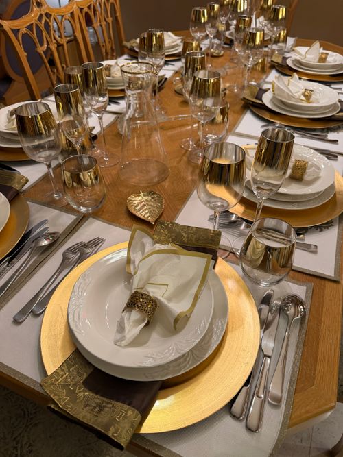 Free Luxurious table setting with gold accents ready for an upscale dinner event. Stock Photo