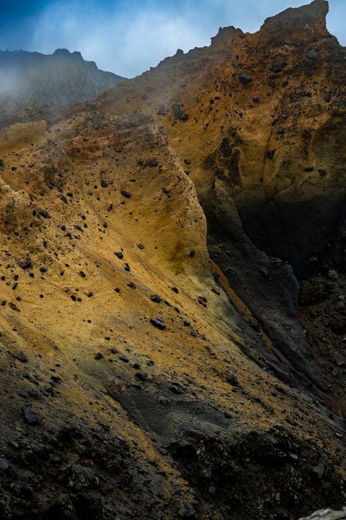 Free Explore the striking colors and textures of a volcanic landscape featuring rugged cliffs and rocky outcrops in remote terrain. Stock Photo