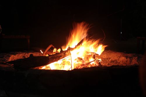 Free A bright, warm campfire burning with logs at night outdoors. Stock Photo