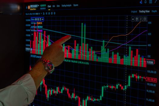 Close-up of a person analyzing Bitcoin market trends on a digital trading platform screen.
