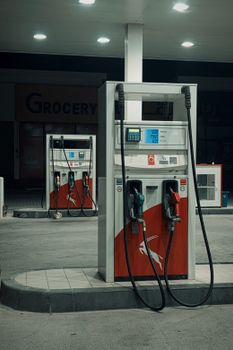 Night view of an empty gas station with illuminated pumps, creating a moody atmosphere.