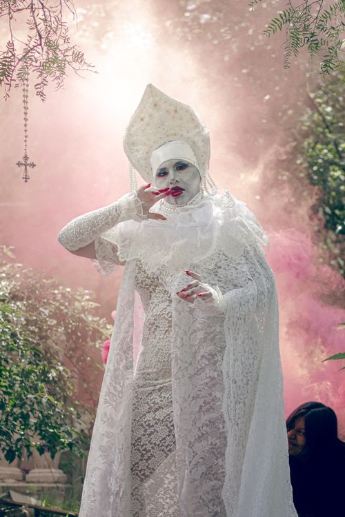 Free Artist in white costume amidst pink smoke in an outdoor setting of Mexico City. Stock Photo