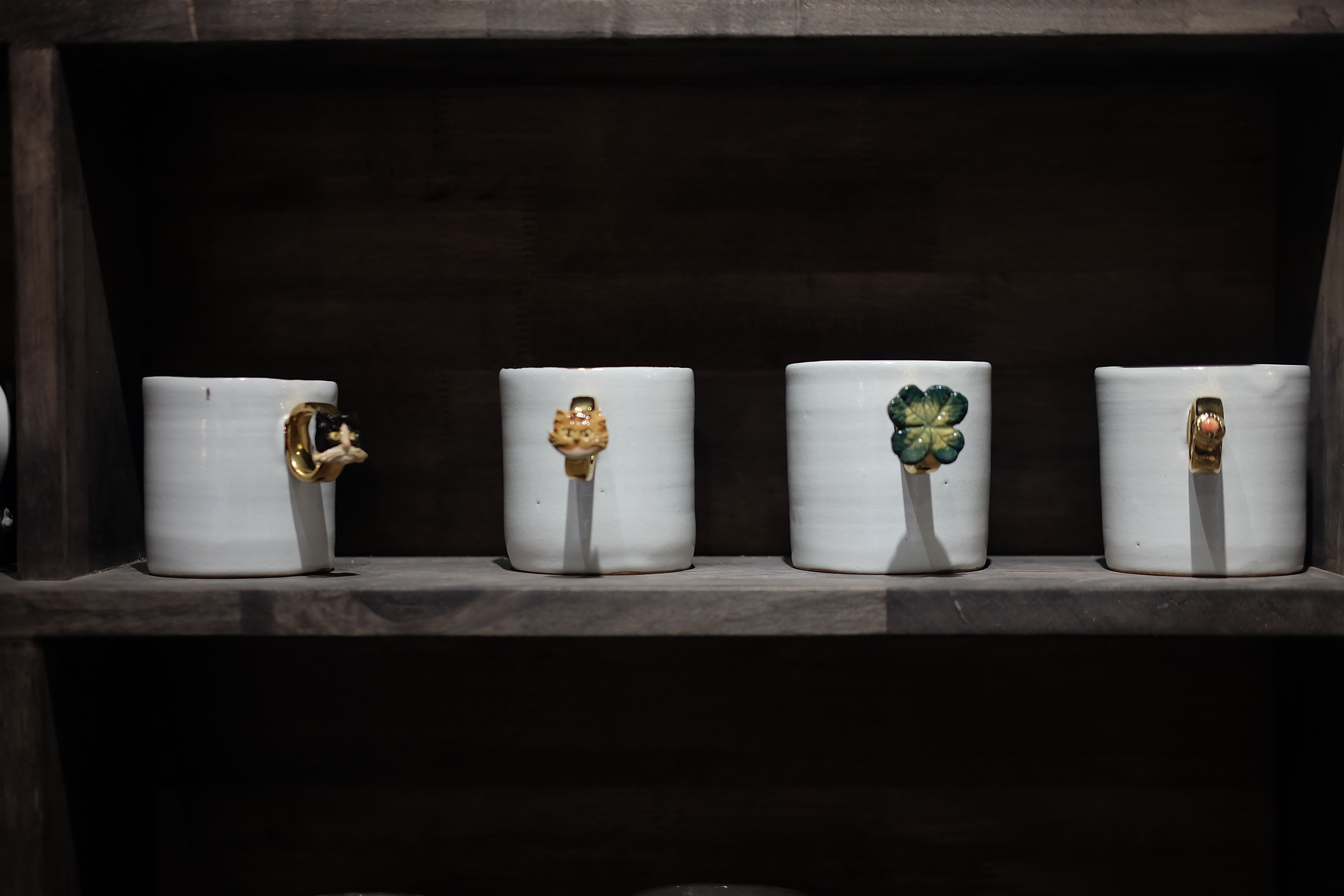A wooden shelf holding a woven basket, ceramic mug and hand-stamped fair-trade greeting cards in warm afternoon light