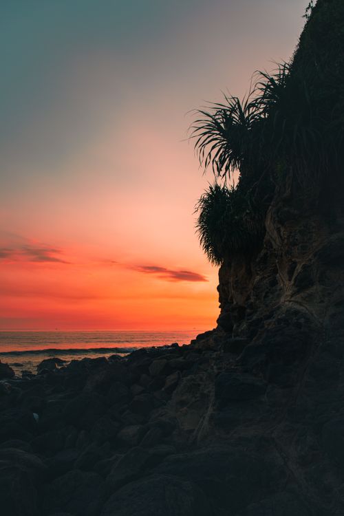Free Breathtaking view of the Haiphong coastline during sunset with vibrant sky and rocky shore. Stock Photo