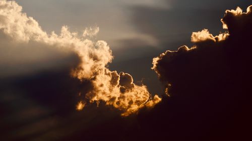 Free Captivating view of dramatic clouds illuminated by the setting sun with warm golden edges. Stock Photo