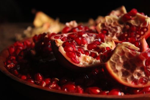 Free Vivid close-up of ripe pomegranate seeds in a rustic setting. Stock Photo
