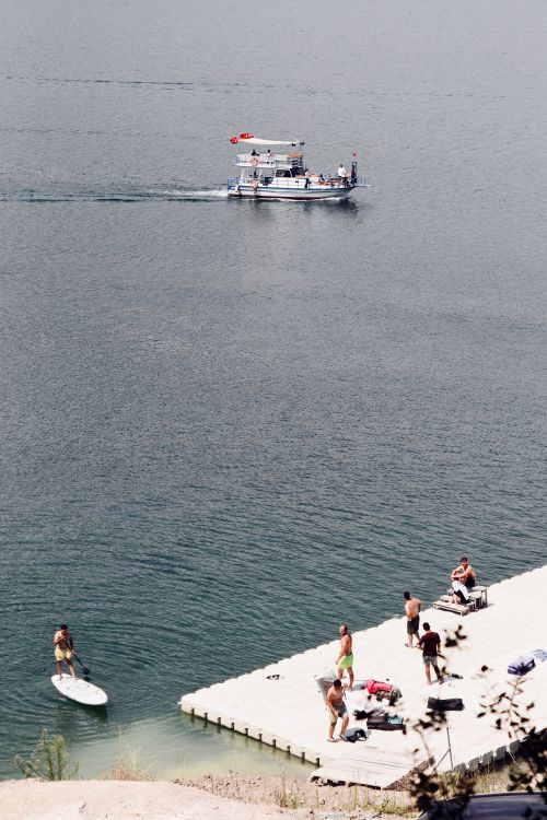 Free People enjoying a summer day by the water with a boat in Samsun, Türkiye. Stock Photo