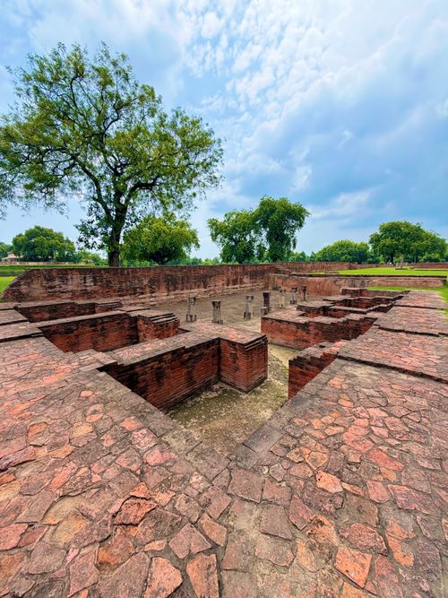 Free Ancient ruins surrounded by lush greenery in Varanasi, India, under a vibrant sky. Stock Photo