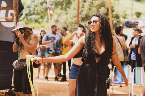 Free A woman enjoying a sunny day at an outdoor festival with friends, celebrating life. Stock Photo