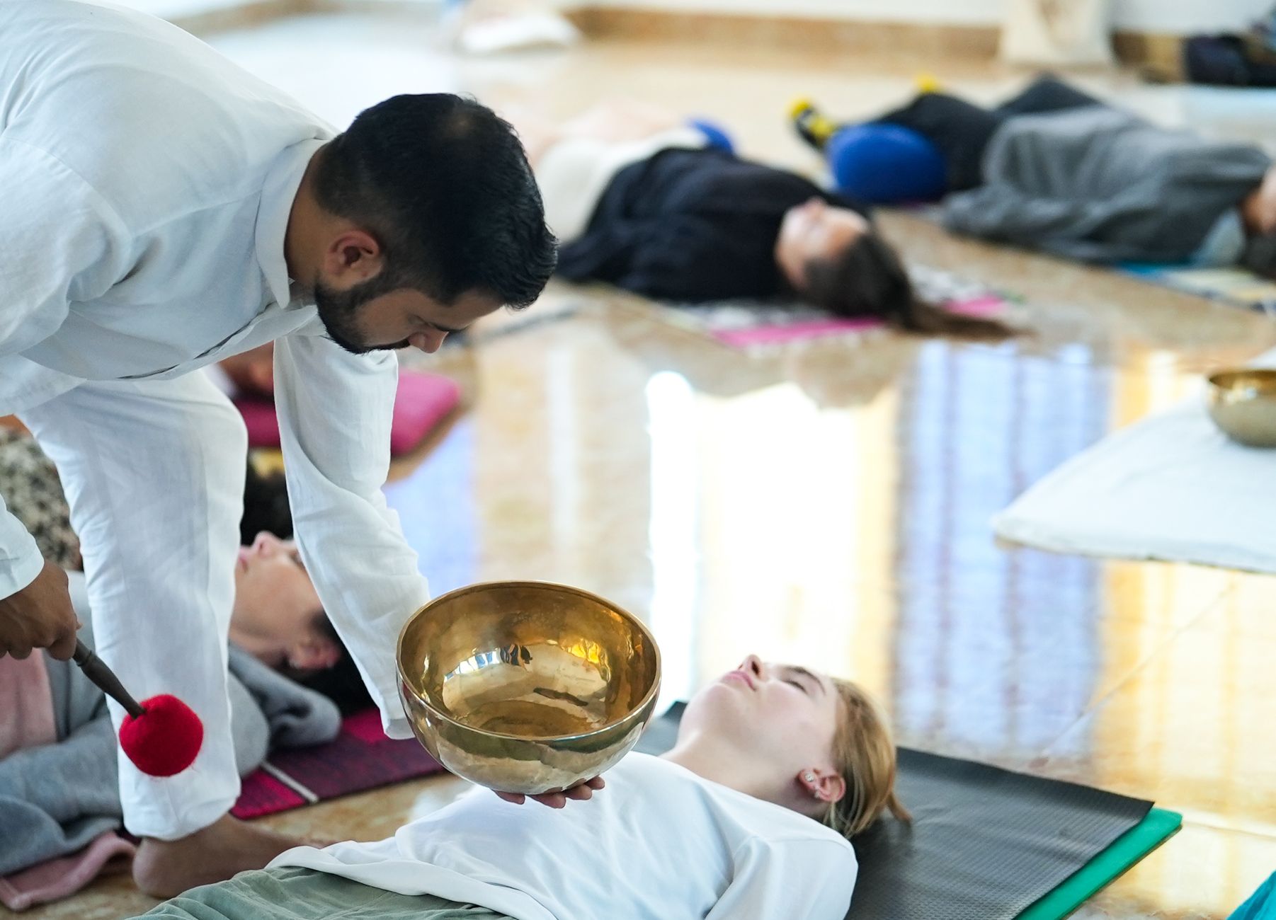 A sound healing session with a practitioner using singing bowls.