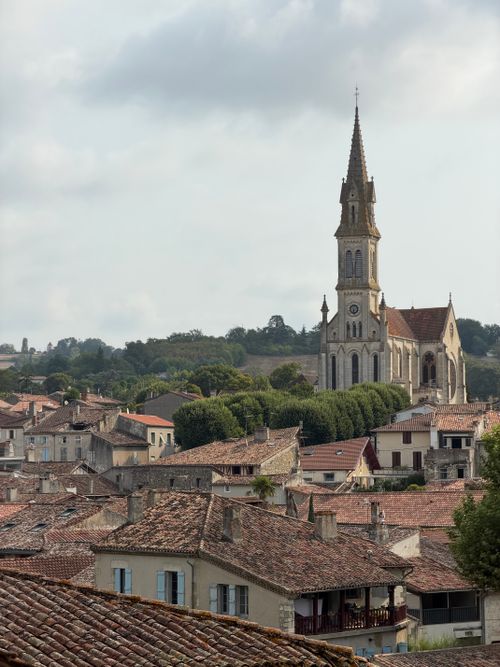 Free A picturesque view of a historic church among charming rooftops in Nérac, France, showcasing classic architecture. Stock Photo