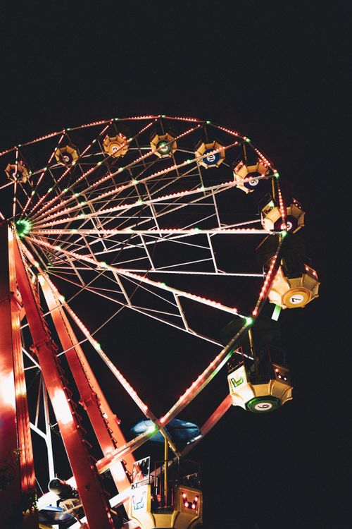 Free Captivating view of a vibrant, illuminated Ferris wheel against the dark night sky. Stock Photo