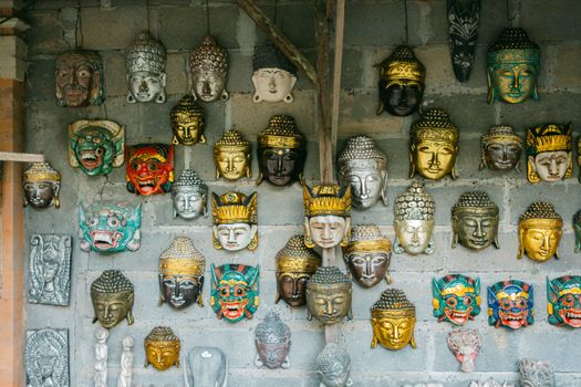 Vibrant traditional masks displayed against a rustic wall, showcasing cultural artistry.