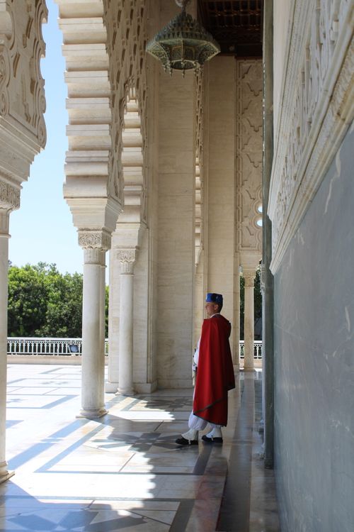 Free A traditional guard stands solemnly at the historic Mohammed V Mausoleum in Rabat, Morocco. Stock Photo