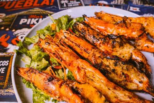 Free Appetizing grilled shrimp served on a bed of fresh lettuce, showcasing vibrant seafood cuisine. Stock Photo
