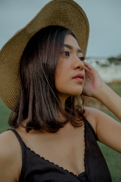 Mujer, En, Negro, Camiseta Sin Mangas, Llevando, Marrón, Sombrero De Sol