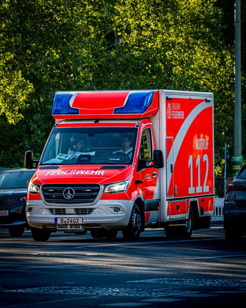 Free Bright red emergency vehicle from the Berlin Fire Department navigating city traffic. Stock Photo