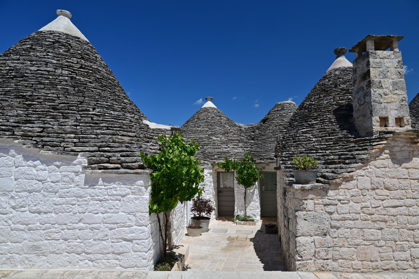 Whitewashed trulli houses with conical stone roofs in Alberobello, Puglia