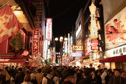 Free Vibrant night scene capturing a bustling crowd and bright neon signs on Dotonbori Street, Osaka. Stock Photo