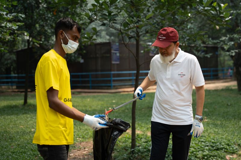 Community volunteers working together to clean a public park area, promoting environmental awareness.