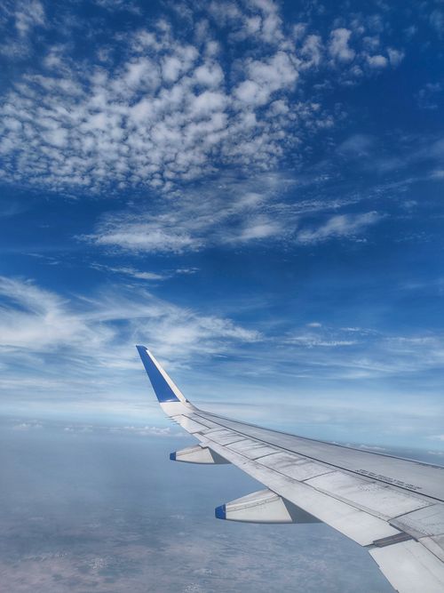 Free Aerial view from airplane featuring blue sky and clouds, perfect for travel themes. Stock Photo
