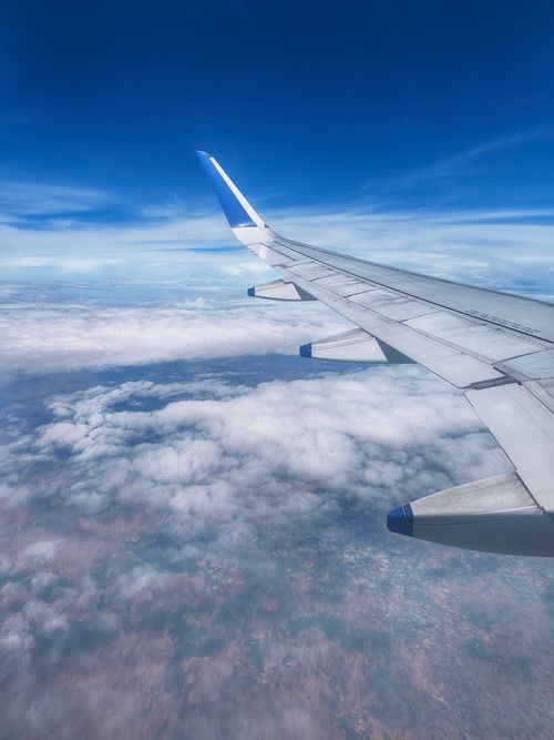 Free Stunning view from airplane window showing clouds and landscape below. Stock Photo