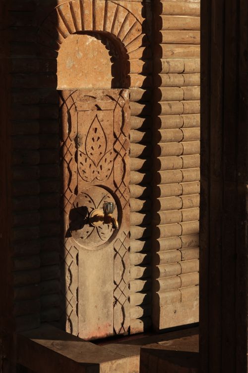 Free A beautifully carved stone fountain illuminated by sunlight, showcasing intricate architectural design. Stock Photo