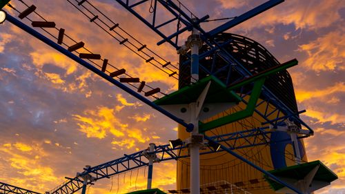 Free A vibrant outdoor rope course silhouetted against a dramatic sunset sky. Stock Photo