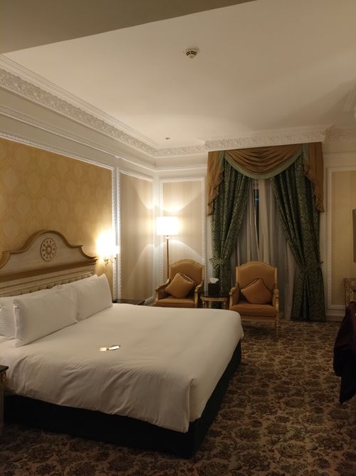 Free A beautifully decorated hotel room featuring a plush bed and classic furniture with warm lighting. Stock Photo