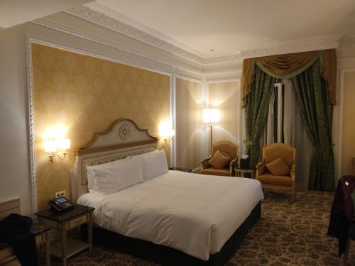 Free Luxurious hotel room featuring a king-sized bed, elegant furnishings, and ambient lighting. Stock Photo