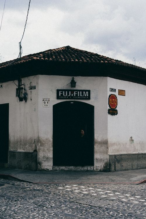 Free Rustic corner building with Fujifilm sign in Antigua Guatemala. Stock Photo