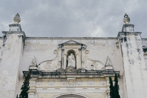 Free A detailed view of historic Baroque architecture with statues on a cloudy day in Antigua, Guatemala. Stock Photo