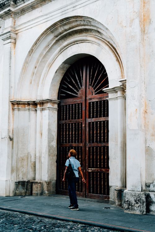 Free A person gazes at an ornate historic door in Antigua, capturing the essence of its colonial architecture. Stock Photo