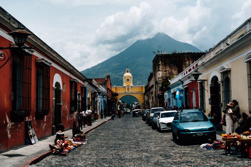 Free Picturesque street in Antigua Guatemala with Santa Catalina Arch and Agua Volcano. Perfect for travel and Latin American culture themes. Stock Photo