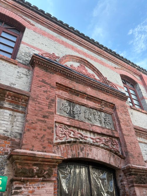 Free Vintage red brick building facade with Chinese architectural details and signage. Stock Photo