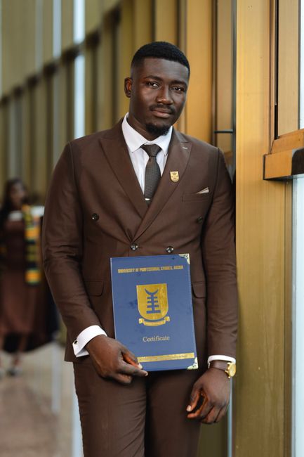 Young adult male in formal attire holding a university certificate at a graduation ceremony. Young adult male in formal attire holding a university certificate at a graduation ceremony.