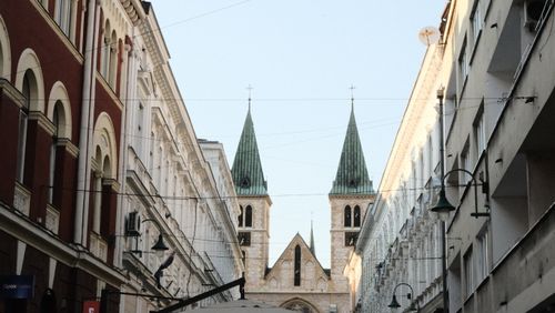 Free Street perspective of Sarajevo Cathedral between historic buildings in Bosnia. Stock Photo