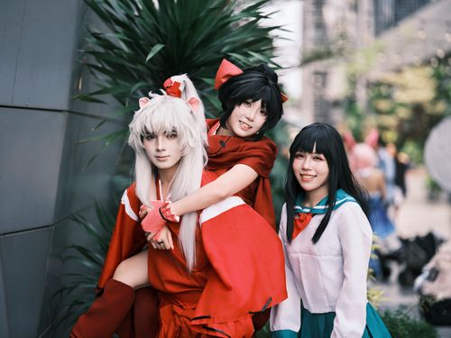 Free Three adults in anime costumes posing playfully at an outdoor convention. Stock Photo
