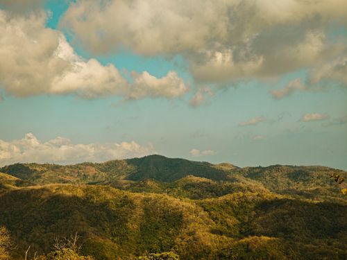 Free A picturesque view of rolling hills and fluffy clouds creating a serene atmosphere. Stock Photo