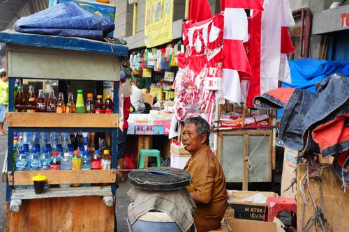 Free Vibrant street scene in Jakarta with a mix of local wares and Indonesia's red-white flags. Stock Photo