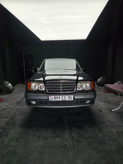 Free Front view of a classic black car in a dimly lit garage with soft overhead lighting. Stock Photo