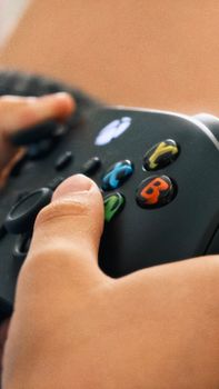 A child intensely focuses on a video game using a black controller.